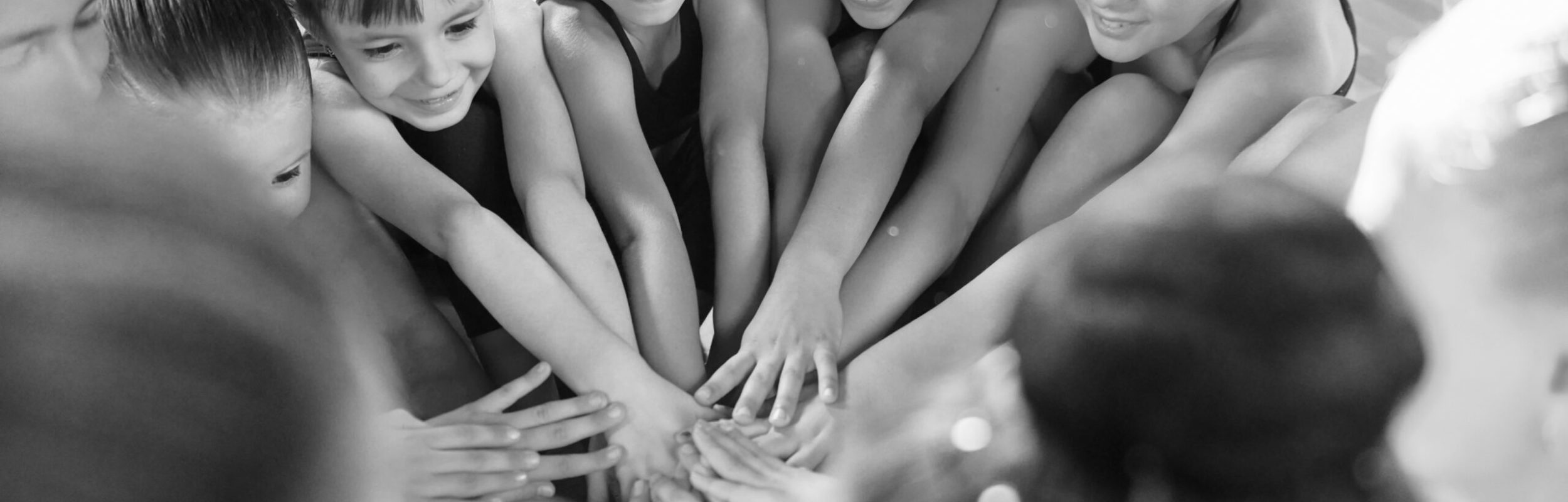 Many of people. Group of female kids practicing athletic exercises together indoors.